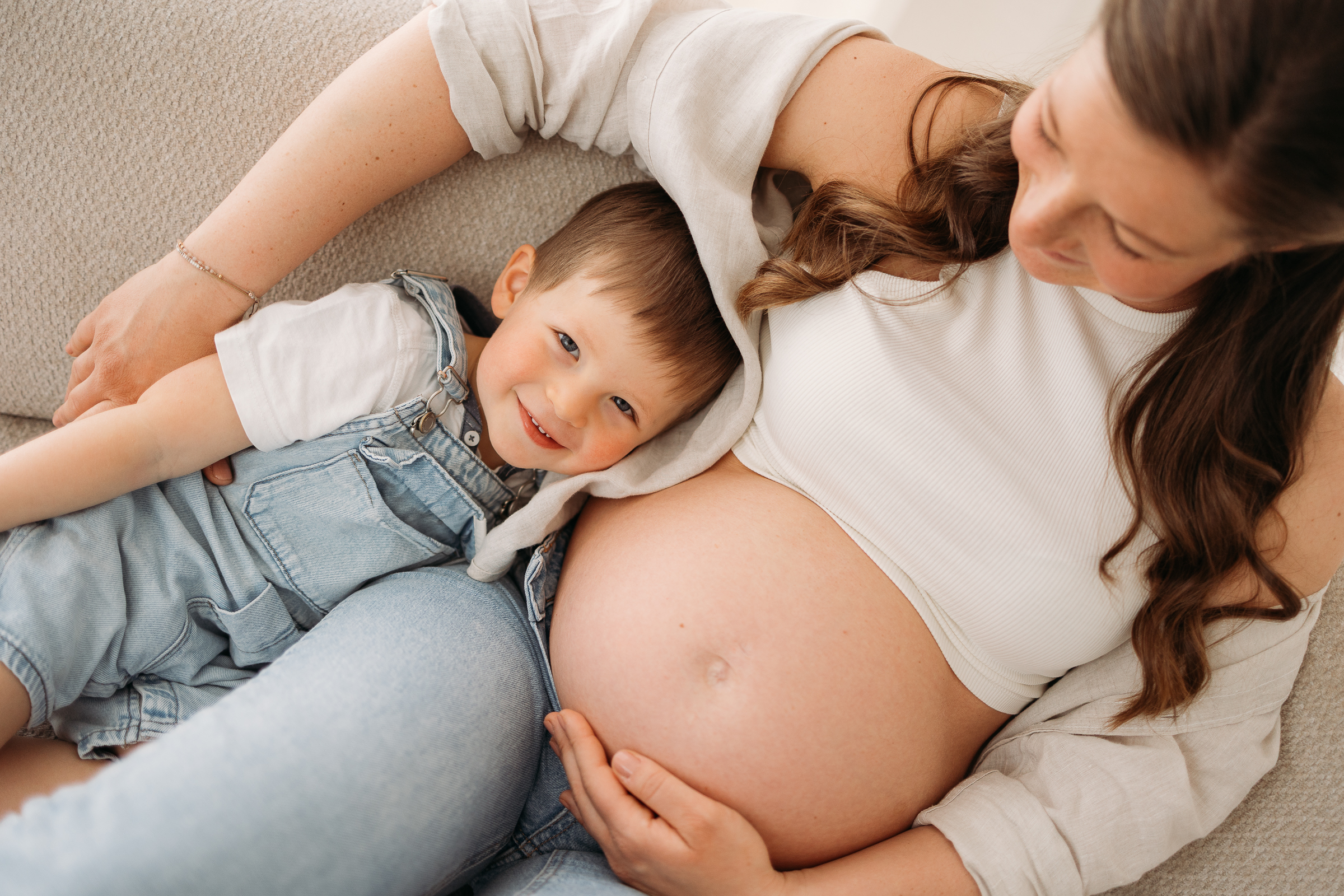 Babybauchshooting im Studio in Hallwang bei Salzburg von Christine Bleisch Fotografie zeigt glückliche Mama mit lachenden Kind